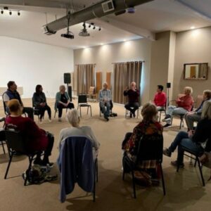 A retreat session in the Sanctuary Learning Center with a group of people sitting in a circle. 